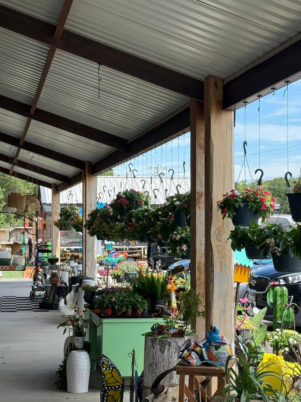 Covered porch at Pick Ur Pots with hanging flower baskets, Talavera-style pots and garden decor