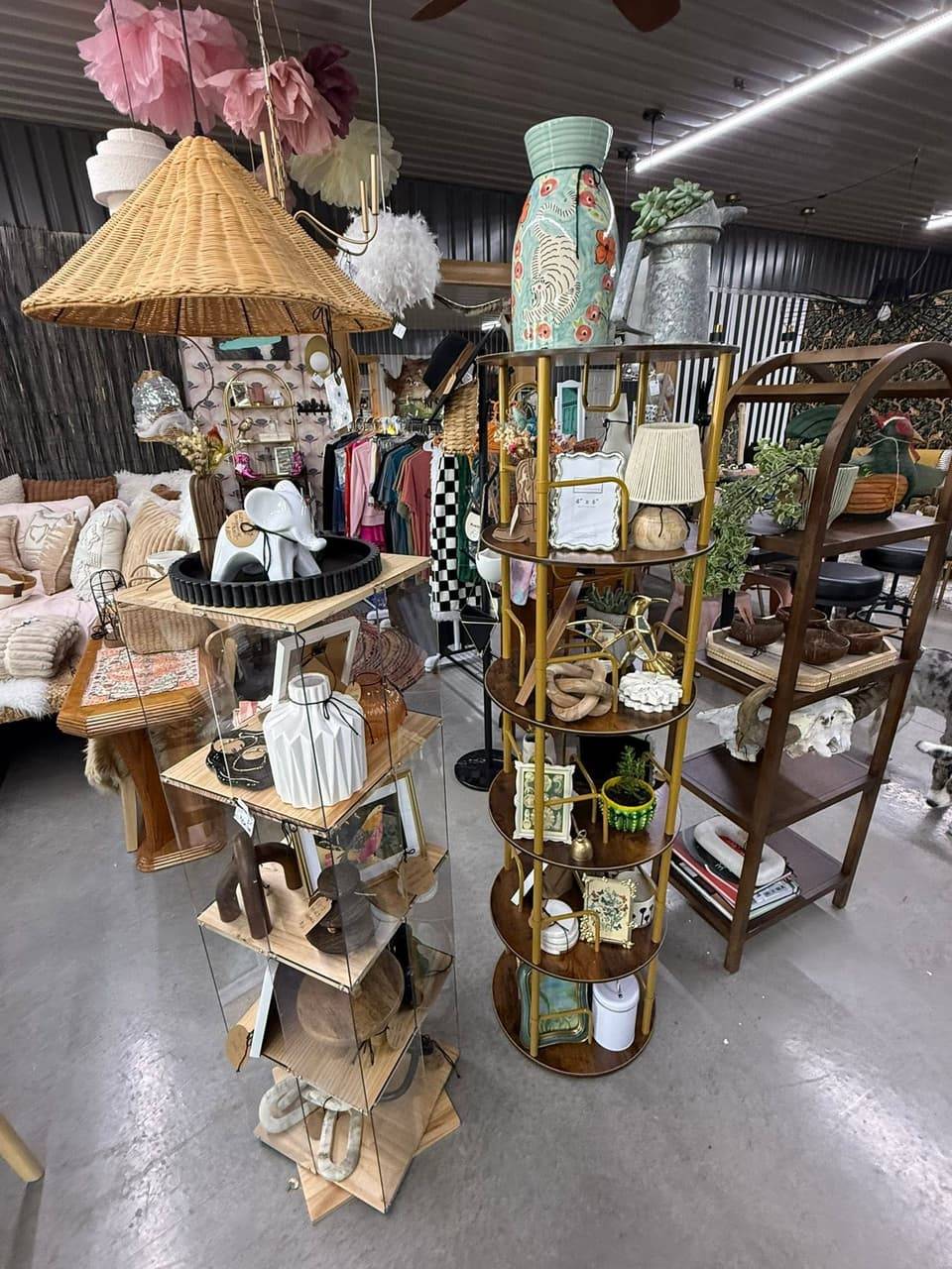 Home decor display with shelving, vases, picture frames, a woven lamp shade and a rattan pendant light
